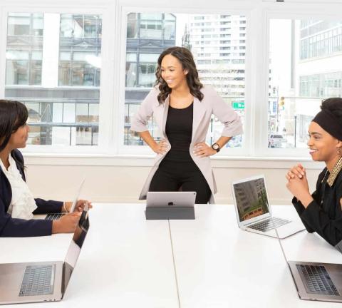MBA vs Excutive MBA: diferencias, ventajas y cuál elegir | EAE BCN Reunión de empresa en el que todos están alrededor de una mesa escuchando a su jefa