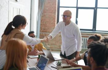 Un empresario hace un acuerdo con un cliente y le da la mano