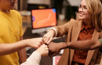 unos compañeros de trabajo chocan las manos 