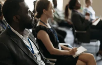 un grupo de personas está sentada mientras escucha una ponencia