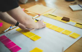 Una trabajadora está escribiendo en post it