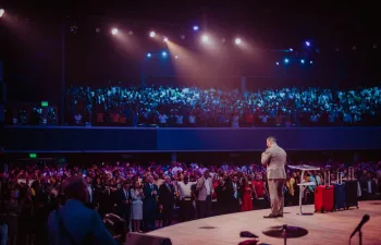 Un hombre está dando una charla a un gran numero de asistentes