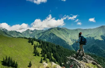 un escalador se encuentra en la cima de una montaña