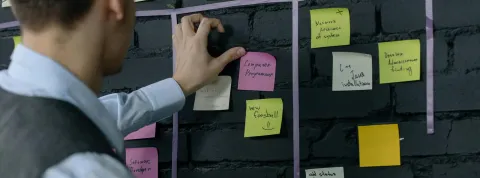 Calendario de tareas en el que un trabajador está organizando los post it