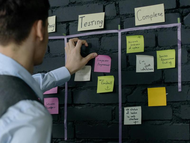 Calendario de tareas en el que un trabajador está organizando los post it