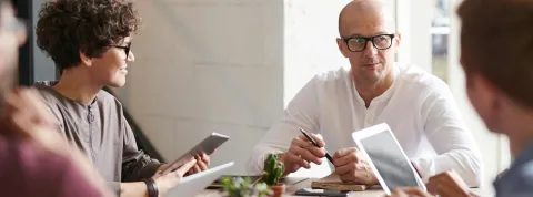 un grupo de trabajadores está charlando encima de una mesa