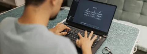 Un chico joven está con su ordenador utilizando un chatbot