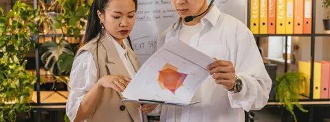 dos trabajadores están viendo gráficas en el despacho