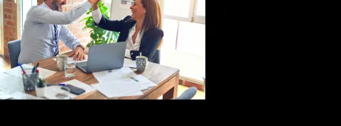 dos trabajadores están en el despacho y se chocan la mano