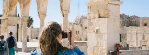 Una turista está fotografiando un monumento romano