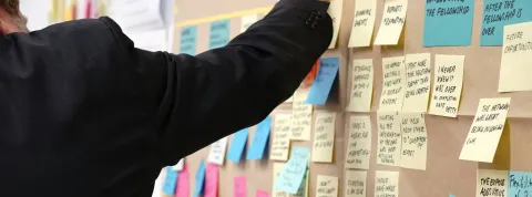 Un trabajador está escribiendo en diferentes post it