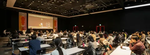 un gran numero de personas se encuentran en una ponencia