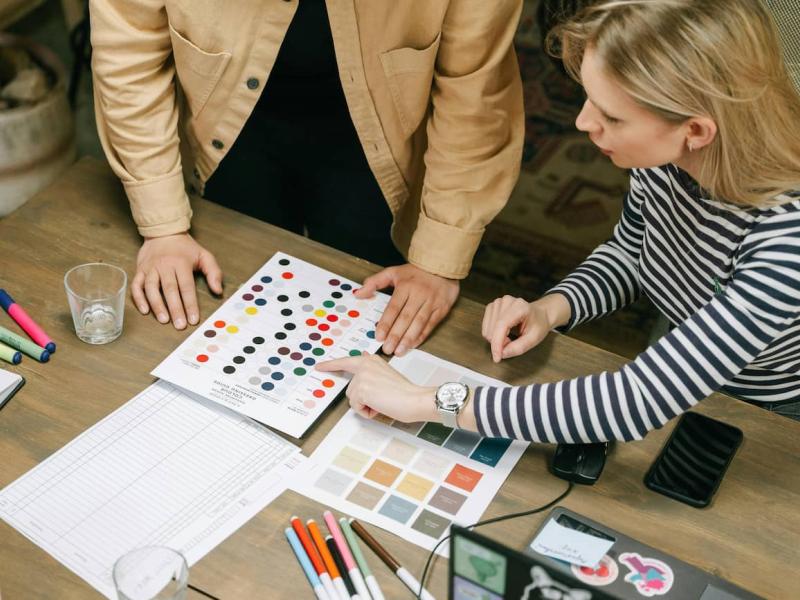 Dos compañeros están eligiendo el color para un logotipo