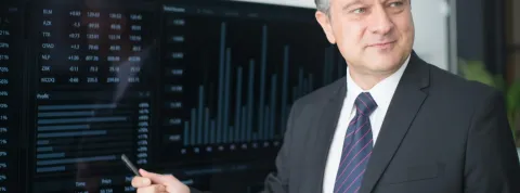 Un empresario está exponiendo en una pantalla estadísticas