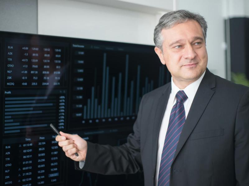 Un empresario está exponiendo en una pantalla estadísticas