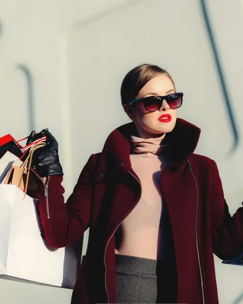 una cleinta está saliendo de una tienda de ropa con muchas bolsas en la mano
