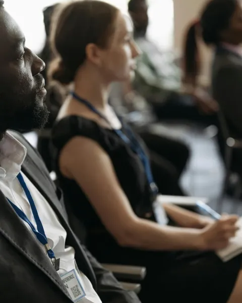 un grupo de personas está sentada mientras escucha una ponencia