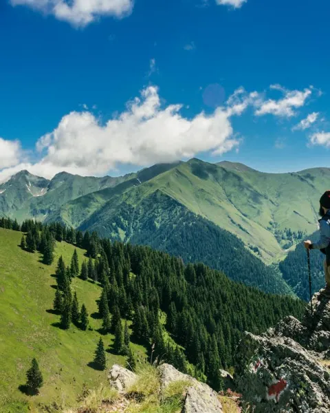 un escalador se encuentra en la cima de una montaña