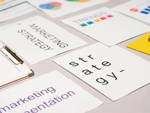 Unos documentos encima de la mesa donde se ven las palabras marketing y strategy