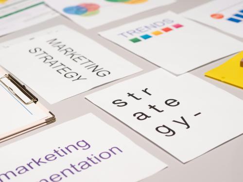 Unos documentos encima de la mesa donde se ven las palabras marketing y strategy