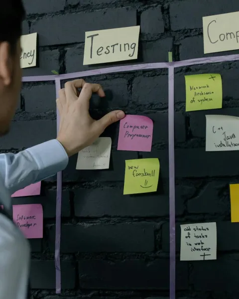 Calendario de tareas en el que un trabajador está organizando los post it