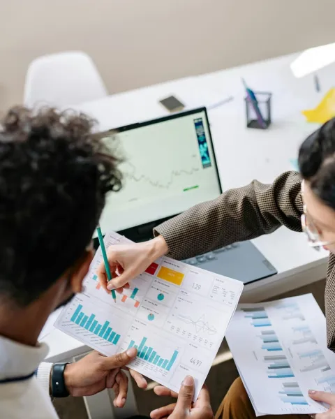 dos compañeros de trabajo están leyendo un informe de finanzas
