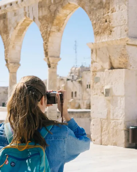 Una turista está fotografiando un monumento romano