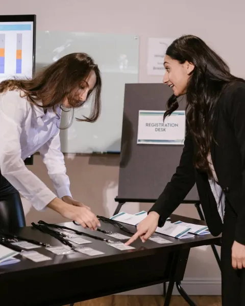 Unas trabajadoras están en un despacho analizando datos y gráficas en un una pantalla