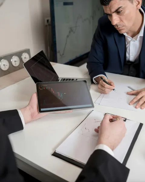 dos empresarios están comparando estadísticas en su despacho