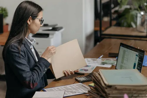 Una empresaria están haciendo leyendo informes en su despacho