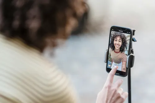 Una influencer está grabándose con le teléfono