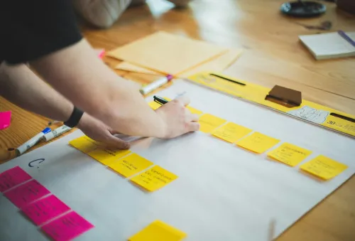 Una trabajadora está escribiendo en post it